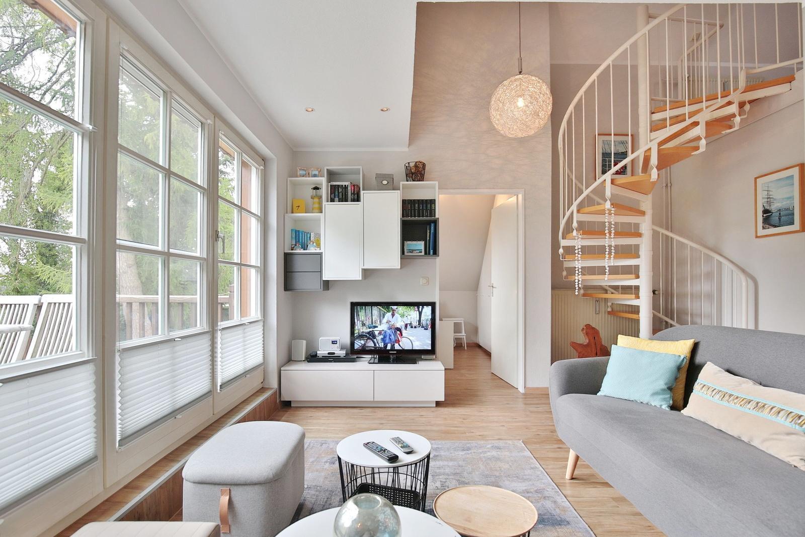 Living room with sofa, TV, and spiral staircase