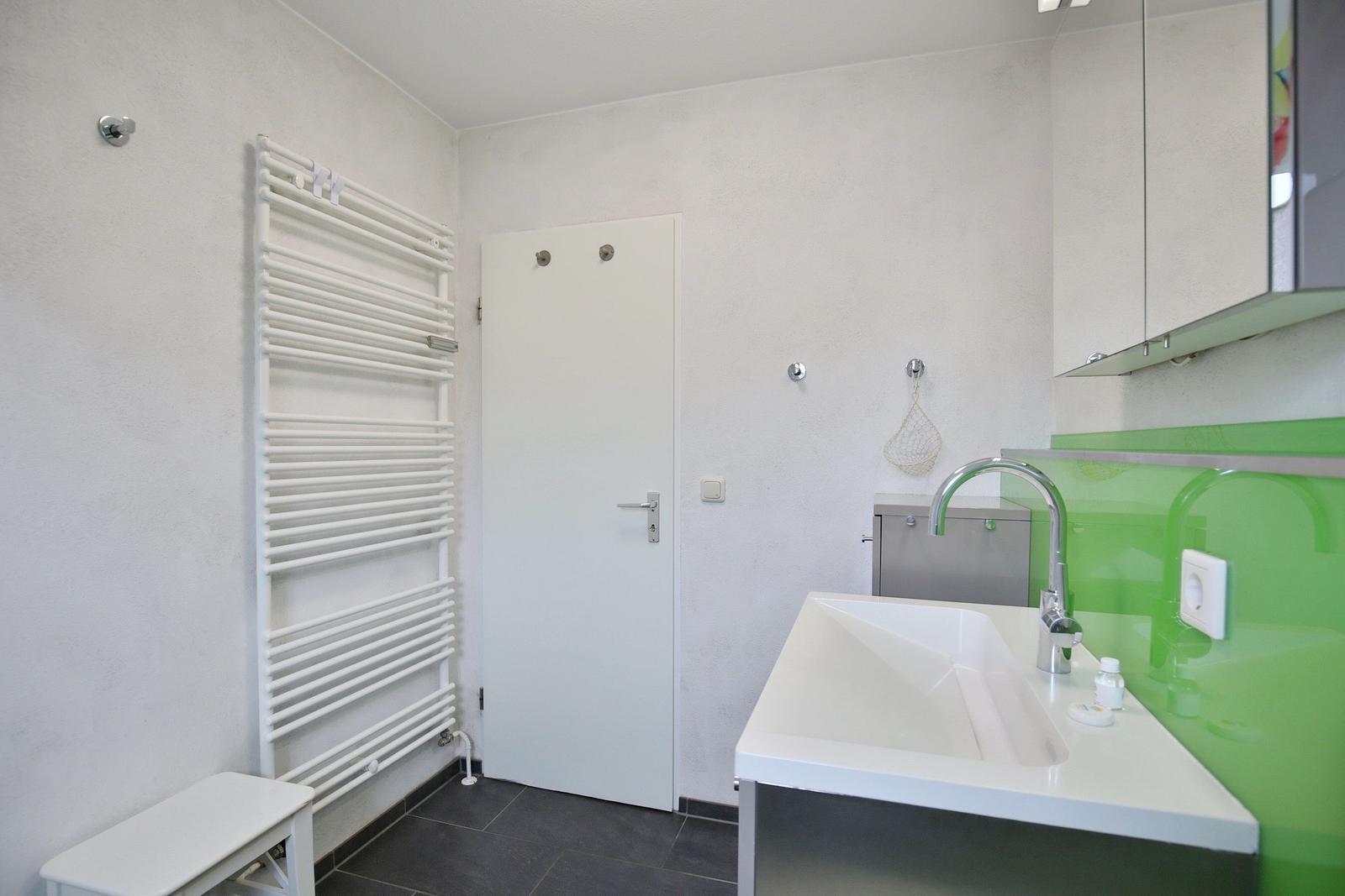 Bathroom with sink, heater, and door.