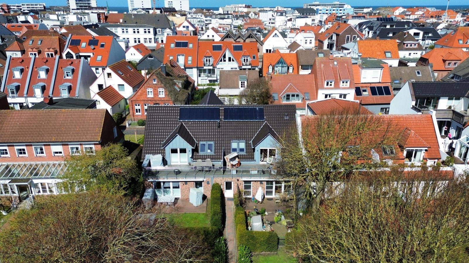 Haus mit Terrasse und Garten in städtischer Umgebung mit Blick auf den Hafen.
