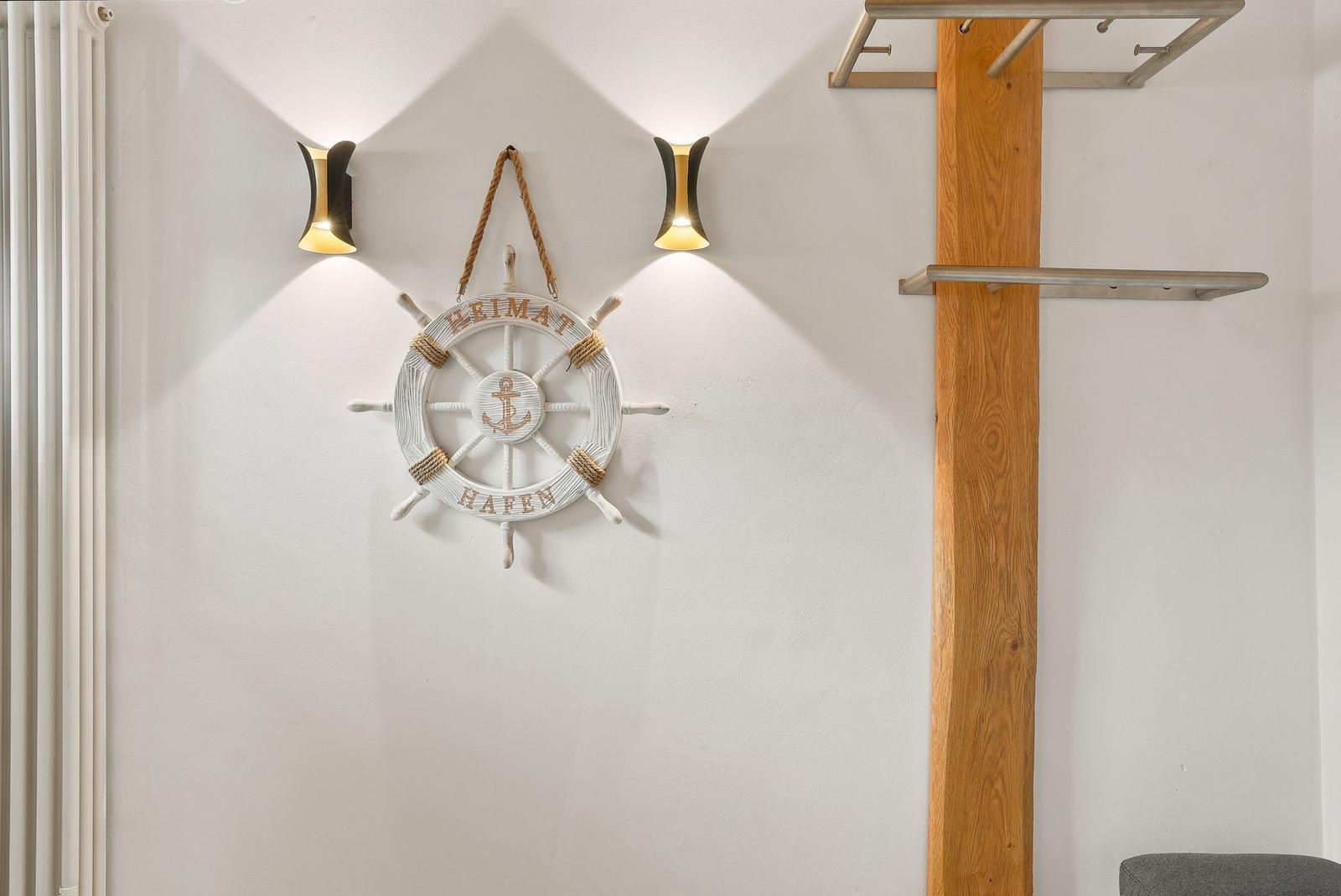 Wand mit Steuerrad, zwei Lampen und Holzpfosten