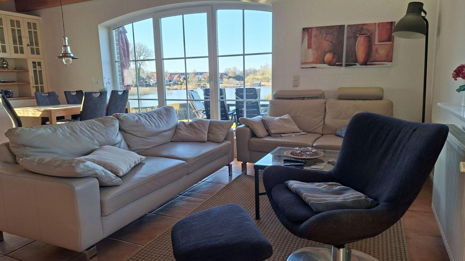 Living room with sofa, armchair, and view of the lake