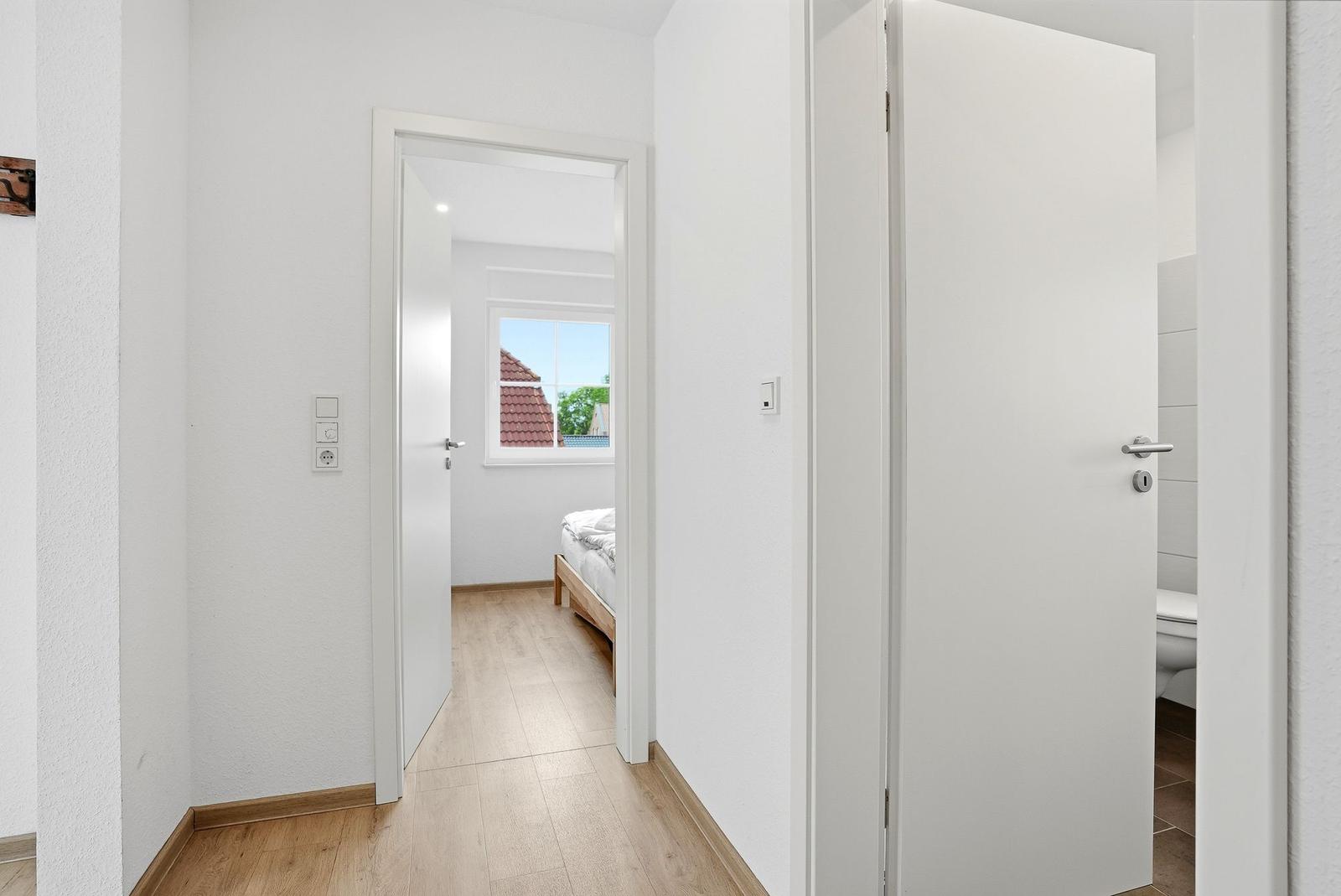 Flur mit Schlafzimmer und Bad. Schlafzimmer hat Fenster mit Blick.