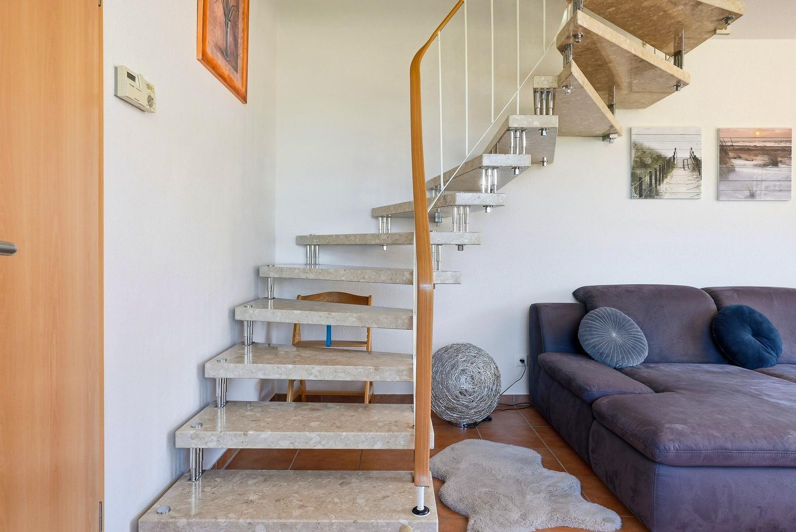 Treppenhaus mit Holzgeländer und Sofa im Wohnbereich