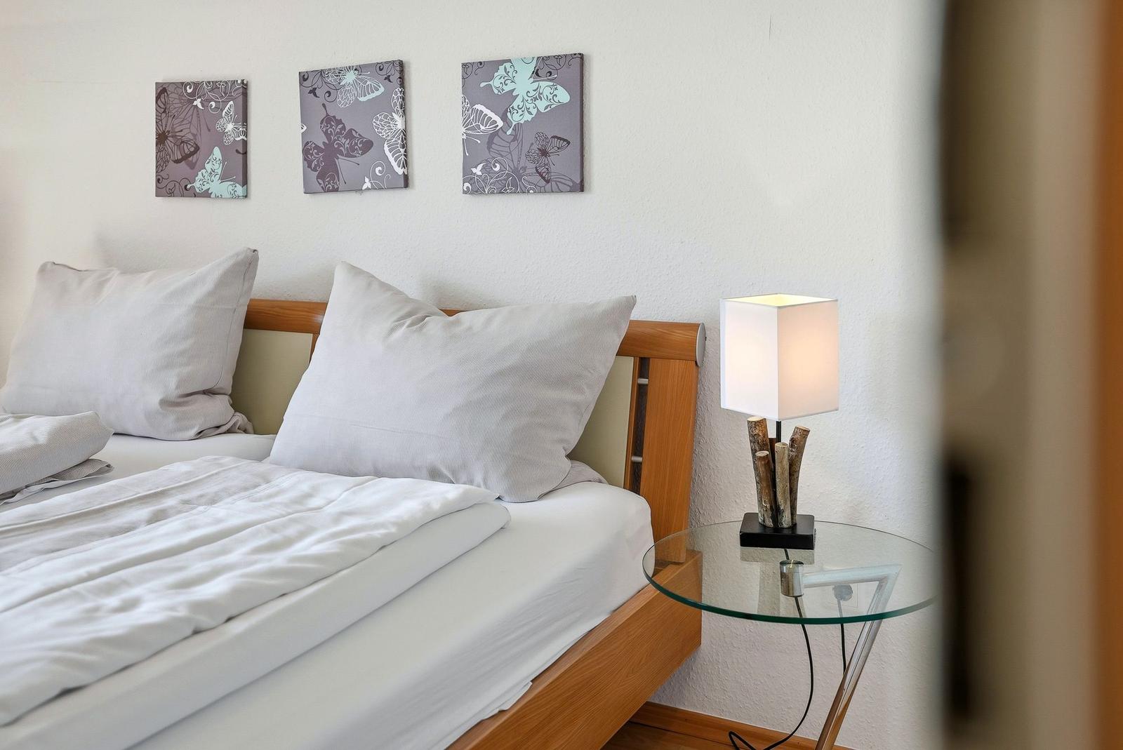 Schlafzimmer mit Bett, Nachttisch und Wandbildern