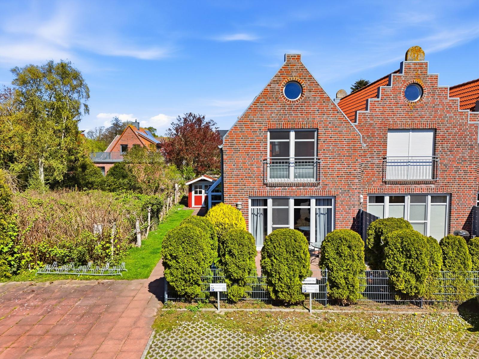 Zwei-geschossiges Backsteinhaus mit Balkonen und gepflegtem Garten. Hinterhof mit Grillplatz.