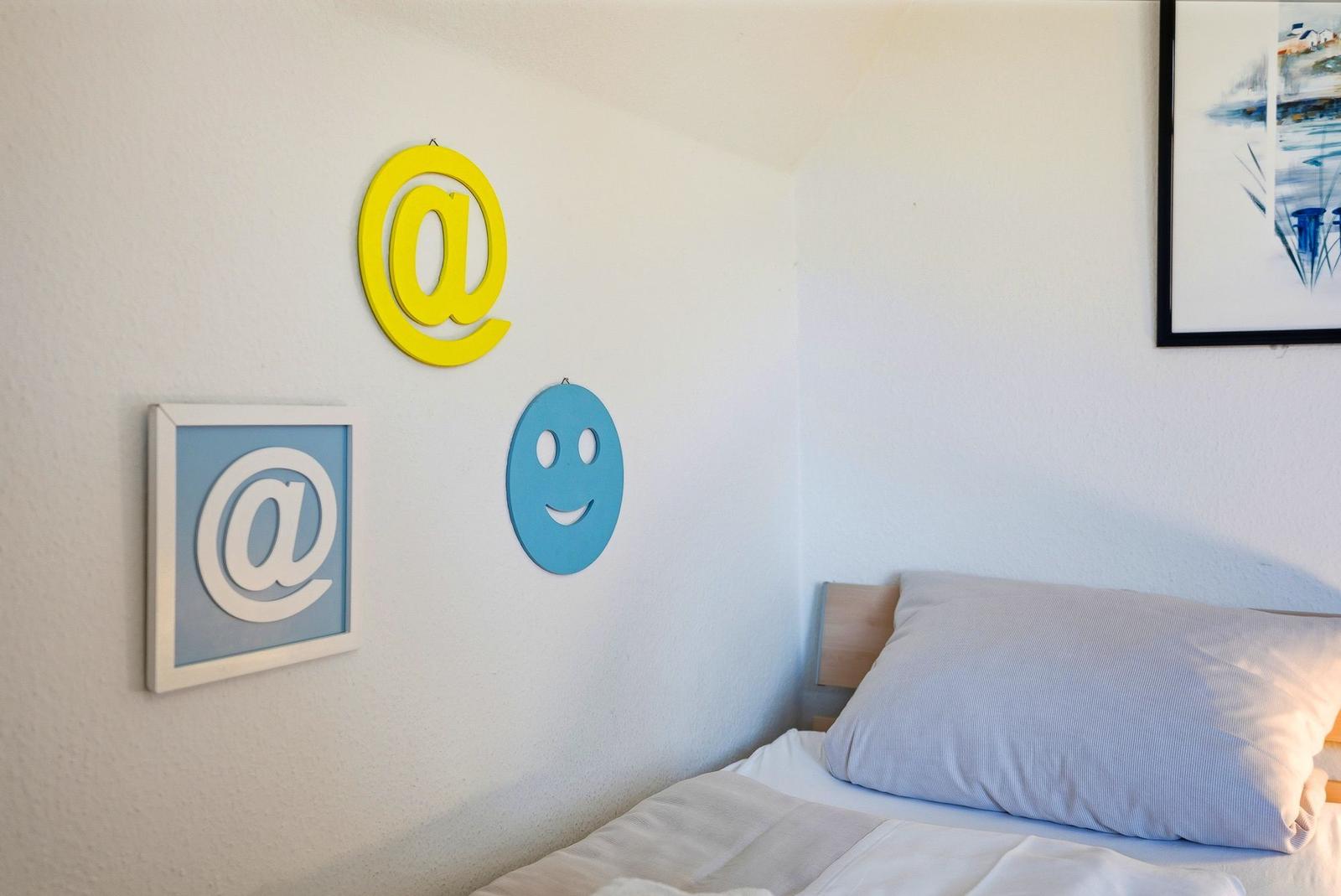 Schlafzimmer mit Bett, Wanddekoration und Bild an der Wand.