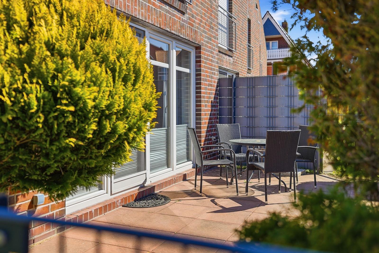 Terrasse mit Sitzgruppe, Fenster und grünen Pflanzen