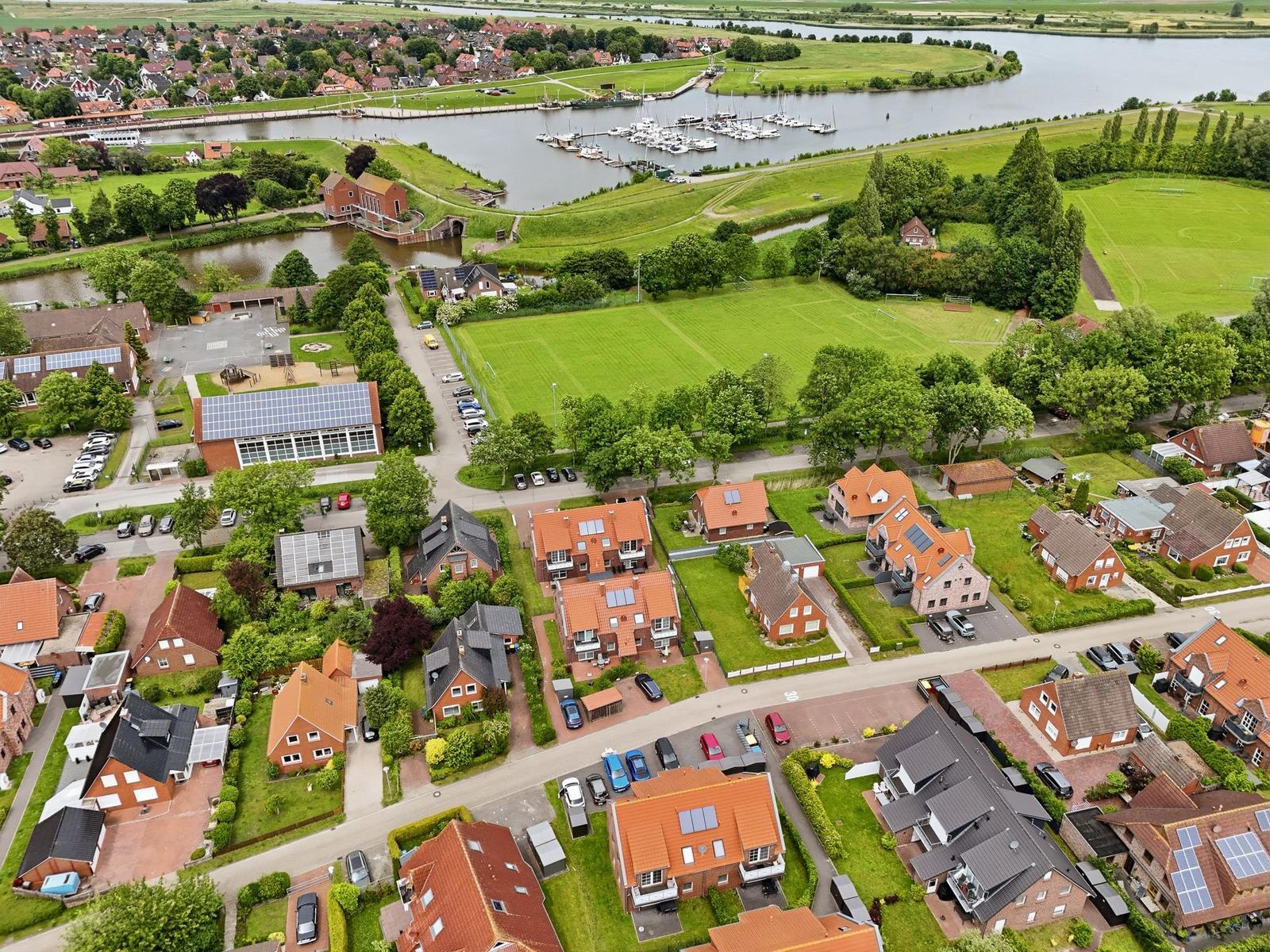 View of residential area with river, marina, and sports field