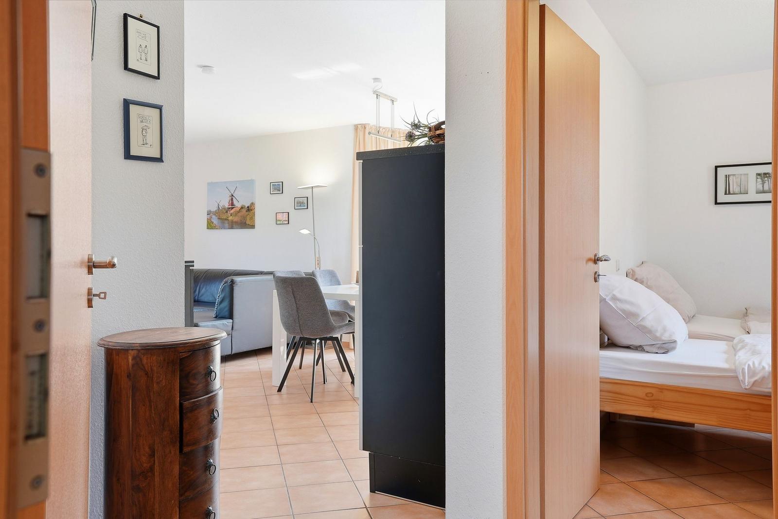 Ein Blick in Wohn- und Schlafzimmer mit Sofa, Tisch, Bett und Schränken.