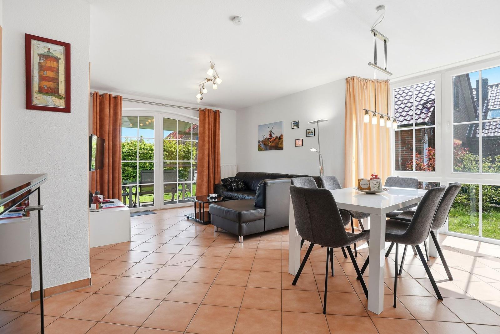 Wohn- und Essbereich mit Sofa, Esstisch und Terrassentür.