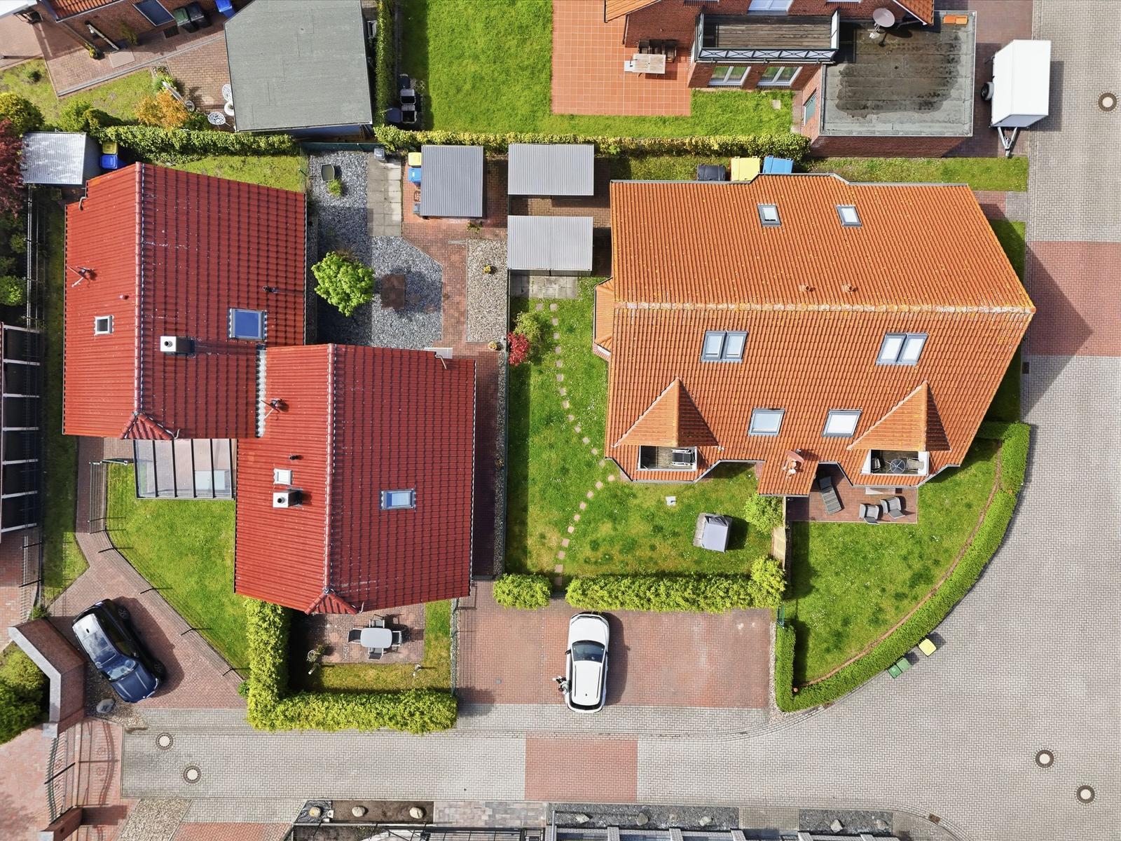 Haus mit rotem Dach, Garten und Parkplatz. Überblick von oben.