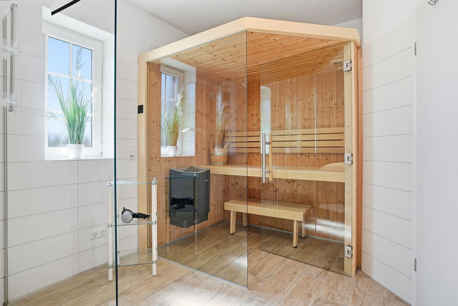 Sauna mit Holzbank und Glaswand in moderner Badezimmerumgebung