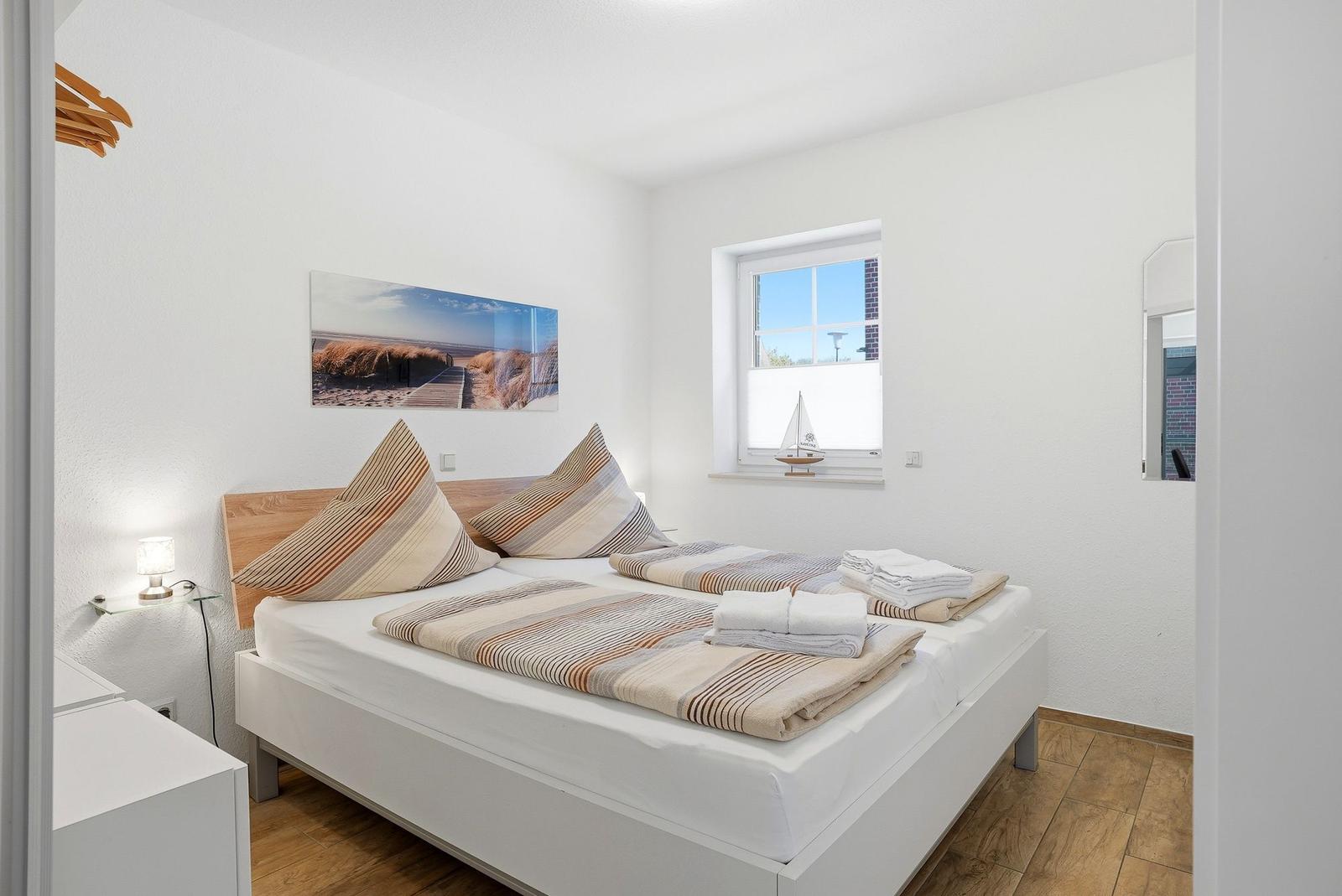 Schlafzimmer mit Bett, Fenster und Wandbild