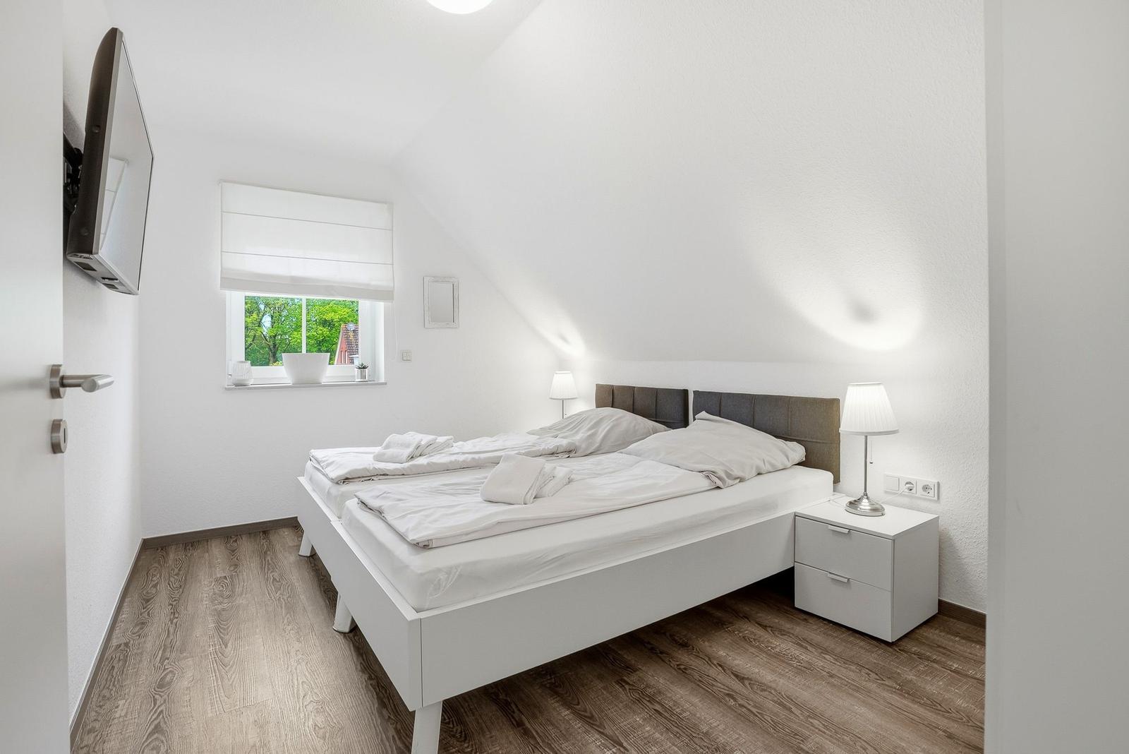 Bedroom with double bed, window, and nightstand