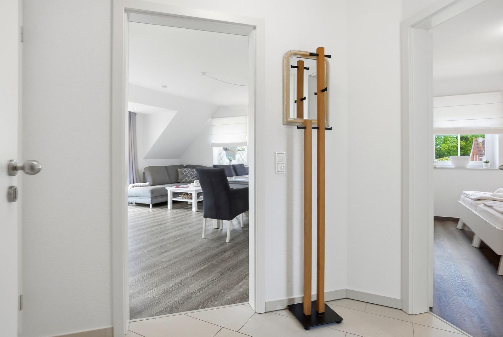 Entryway with coat stand and view into living and bedroom.