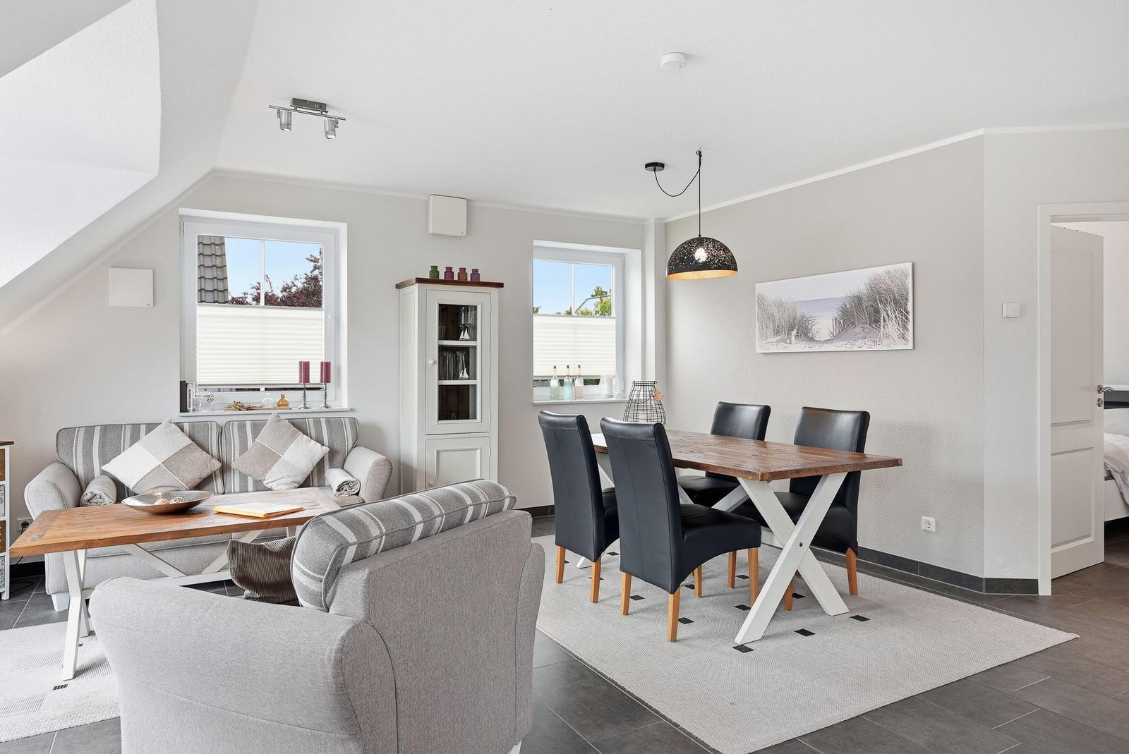 Living and dining area with sofa, dining table, and windows.