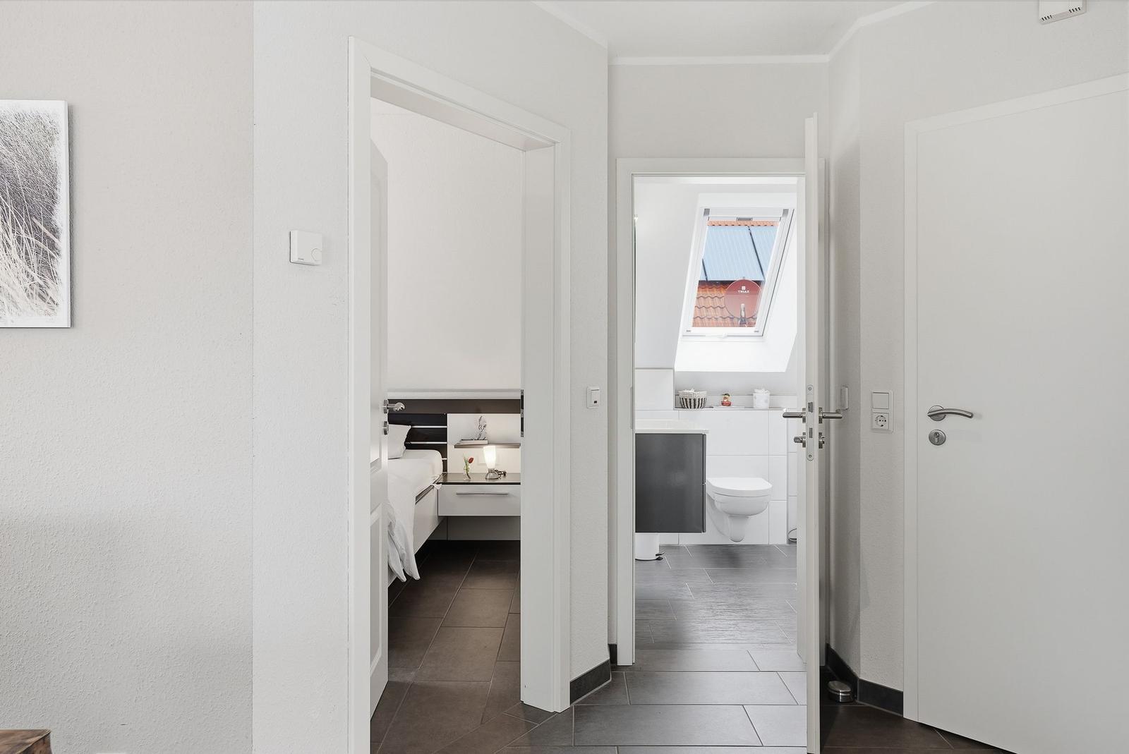 Bedroom and bathroom with skylight and modern furnishings.
