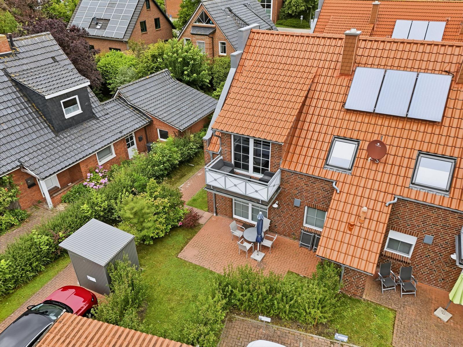 Red roof with solar panels, balcony, and terrace with garden.