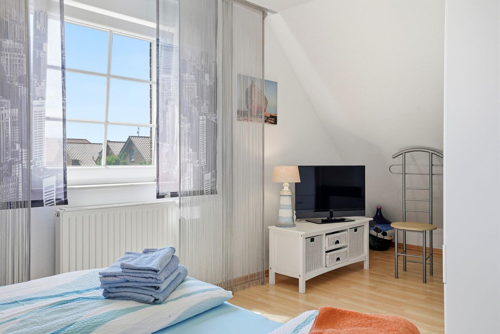 Zimmer mit Blick auf Stadt, Bett, Fernseher und Stuhl.
