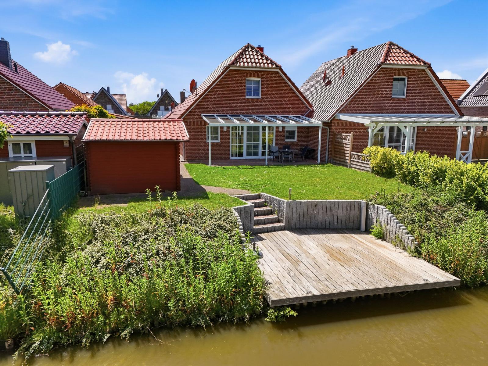 Haus mit Terrasse und Bootssteg am Kanal