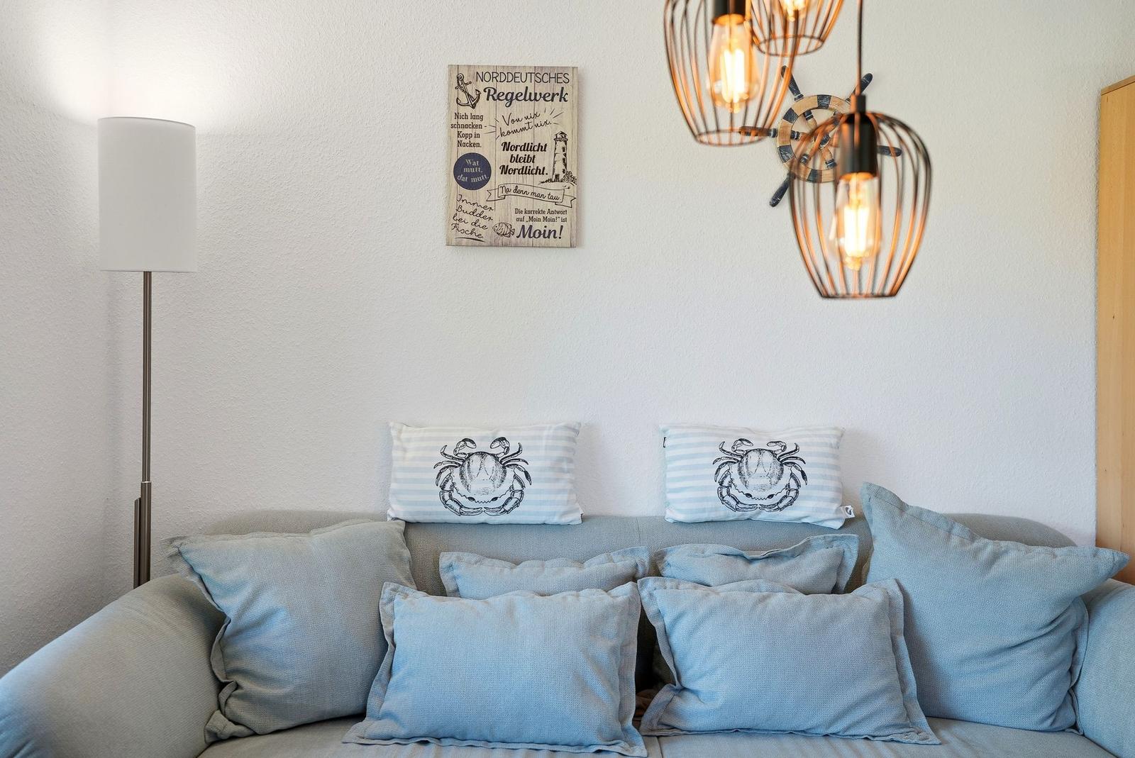 Ein Sofa mit Kissen, Wanddekoration und Hängelampen.