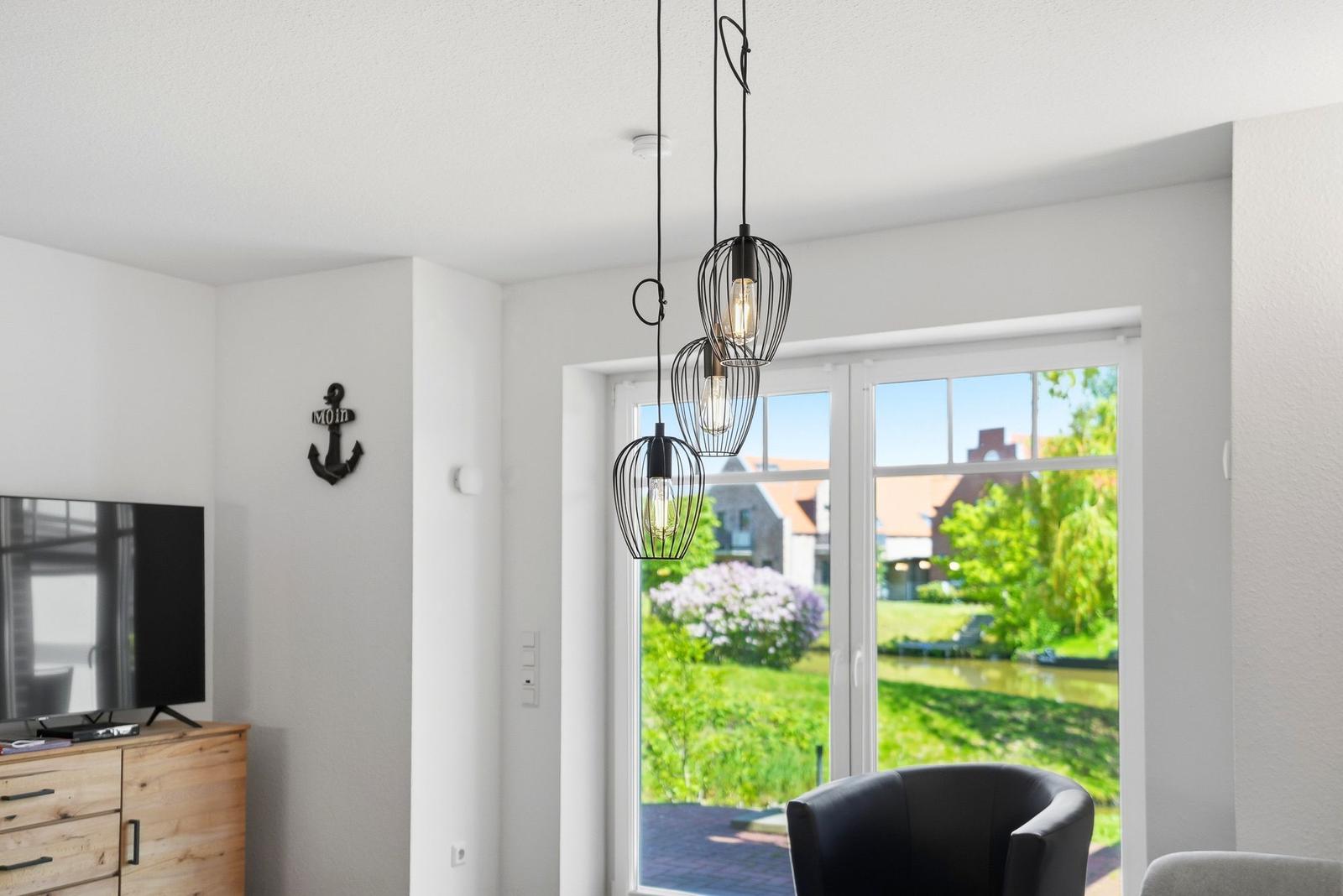 Raum mit Fernseher, Ankerdekoration und Blick auf Garten.