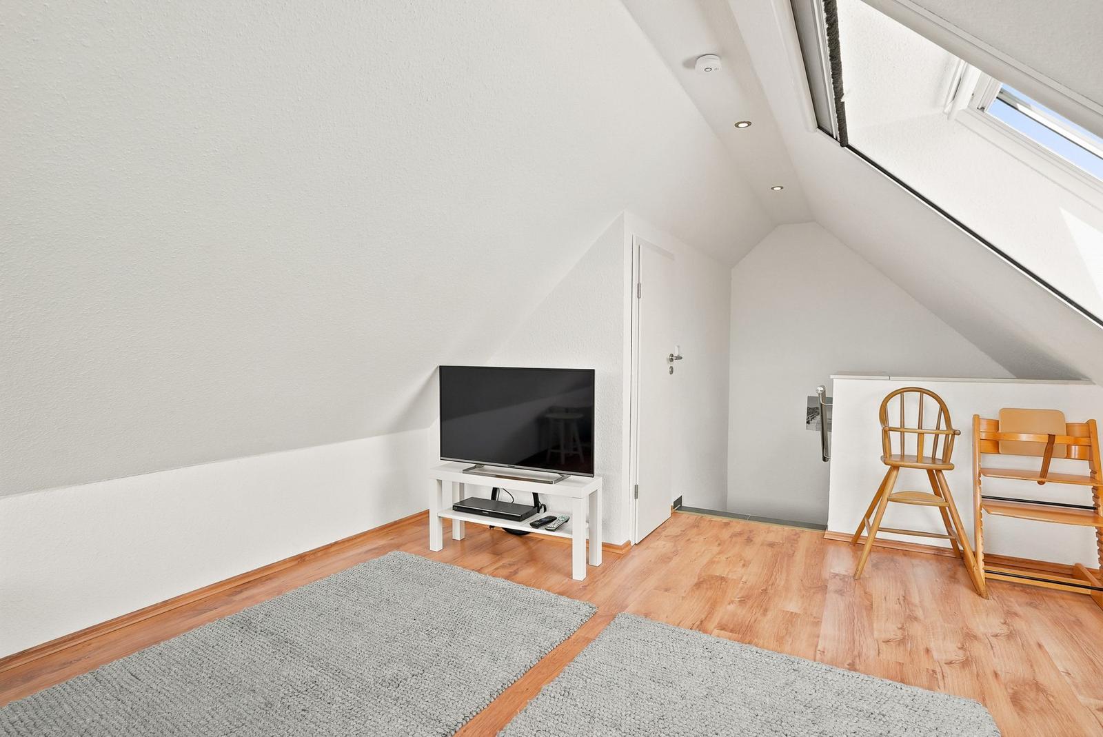 Zimmer mit Dachschräge, TV, Holzboden und Kinderhochstuhl