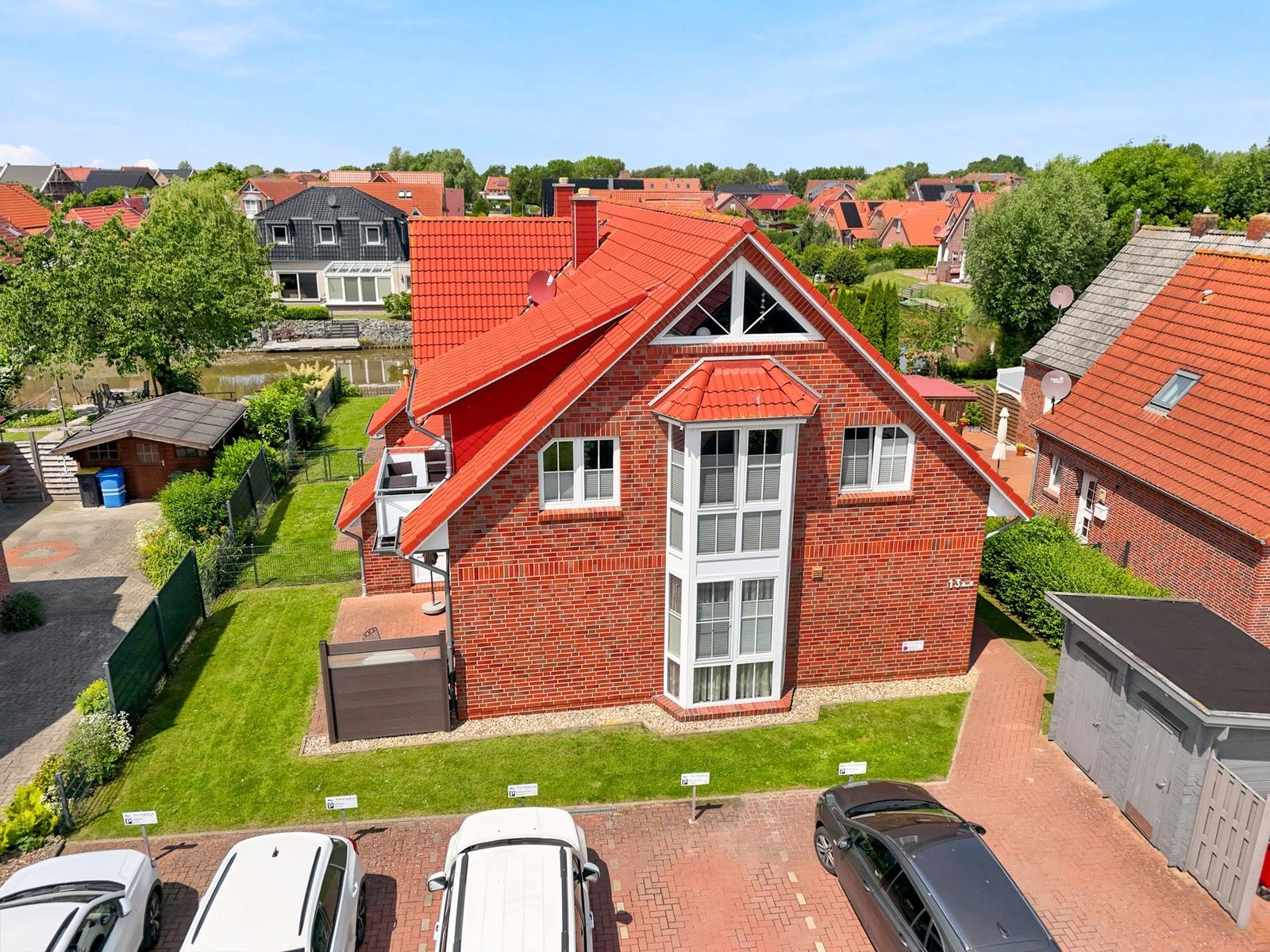 Rotes Ziegelhaus mit Garten und Parkplatz in ruhiger Wohngegend.
