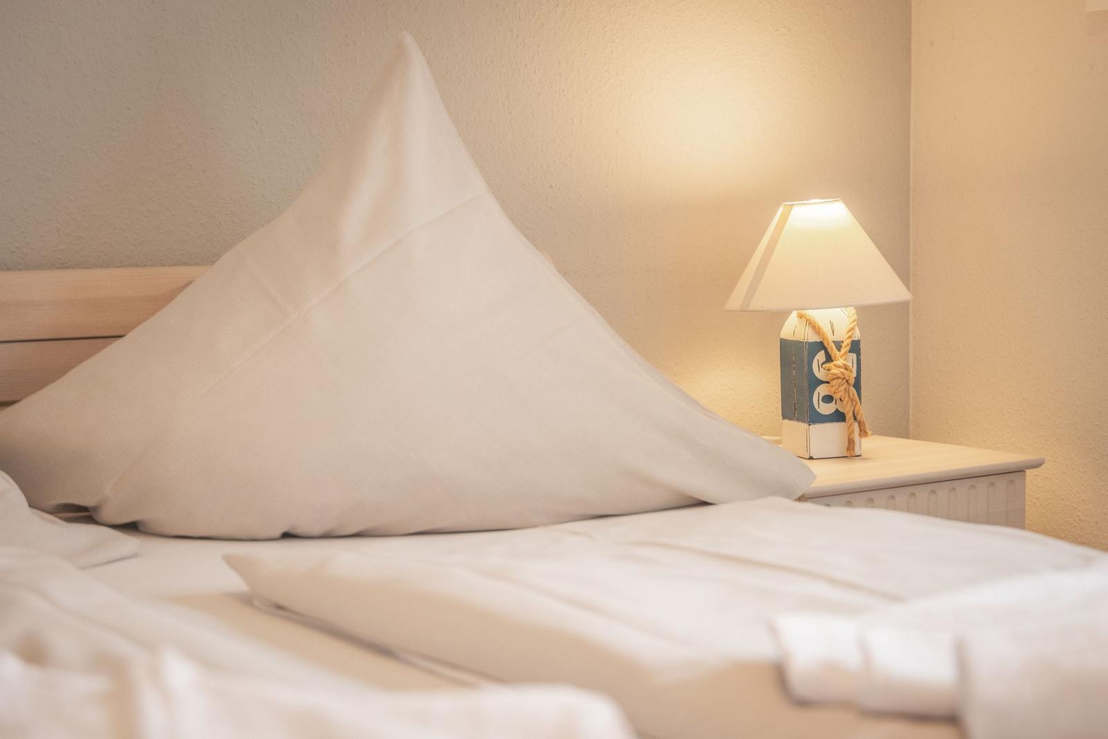 Bettkopfteil mit Kissen und Nachttisch mit Lampe