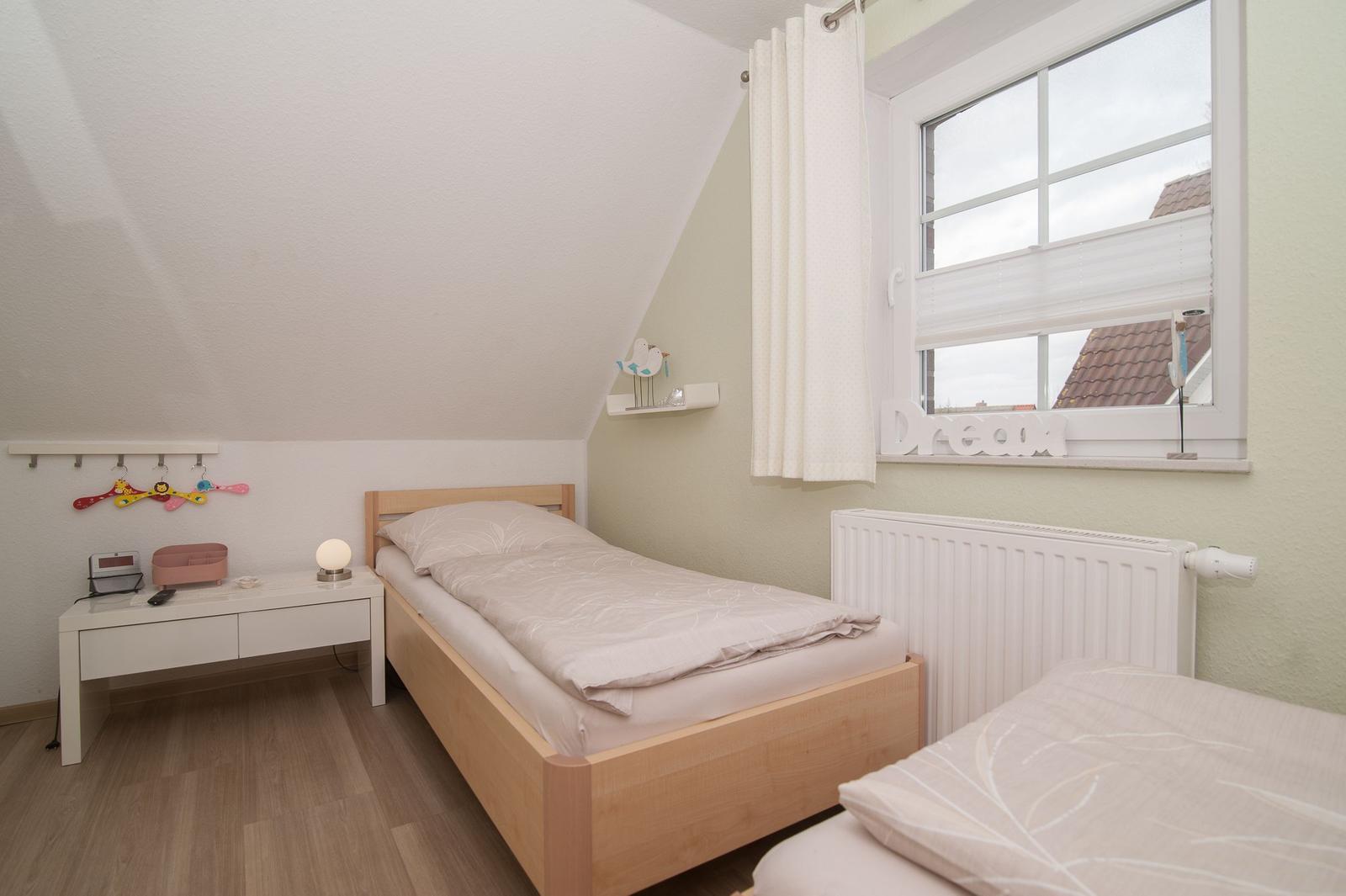 Schlafzimmer mit einem Bett, einem Schreibtisch und einem Fenster.