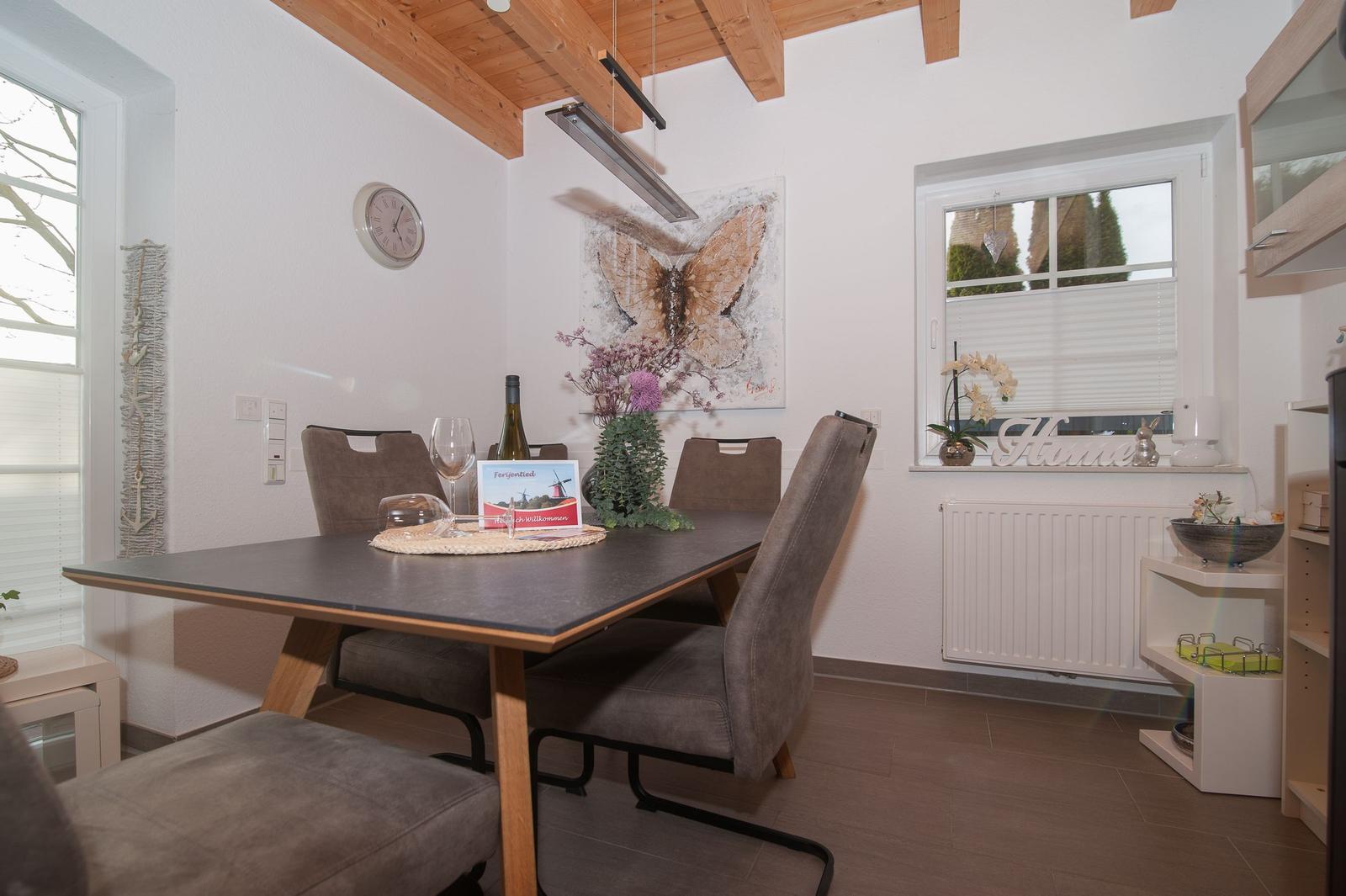 Esszimmer mit Tisch, Stühlen und Wandbild
