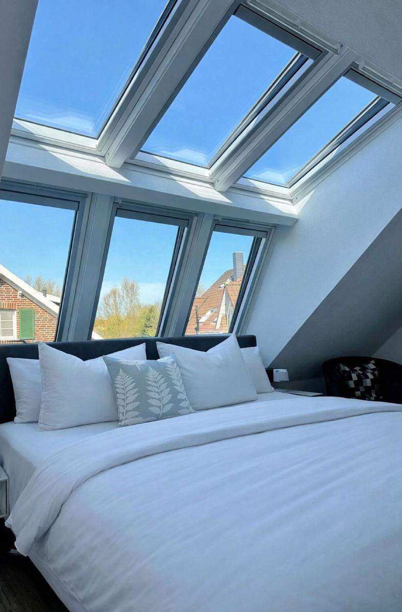 Schlafzimmer mit Dachfenster und Blick auf die Umgebung.