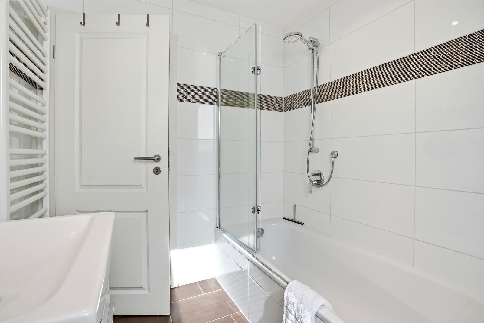 Badezimmer mit Dusche, Badewanne und Heizkörper