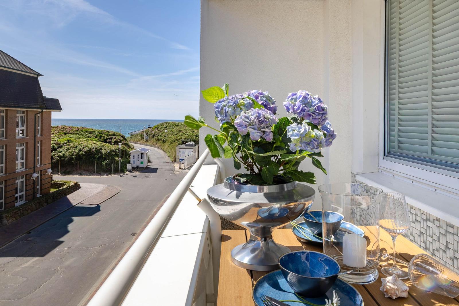 Balkon mit Blumen, Tisch und Meerblick