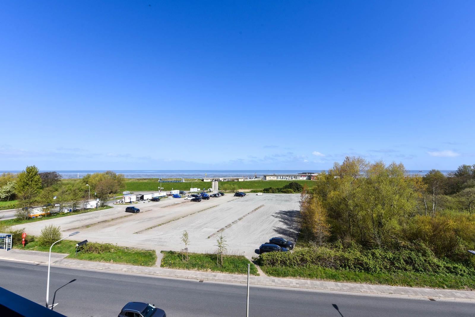 Weitläufiger Parkplatz mit Blick aufs Meer und grüne Bäume