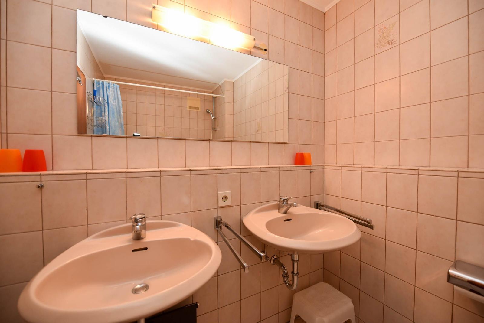 Badezimmer mit zwei Waschbecken, Spiegel und Dusche