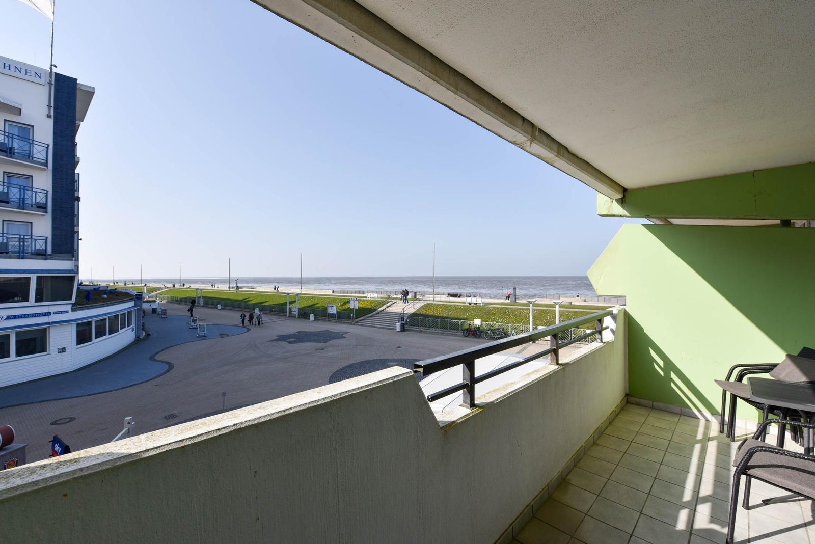 Balkon mit Tisch und Stühlen, Blick auf Strand und Meer.