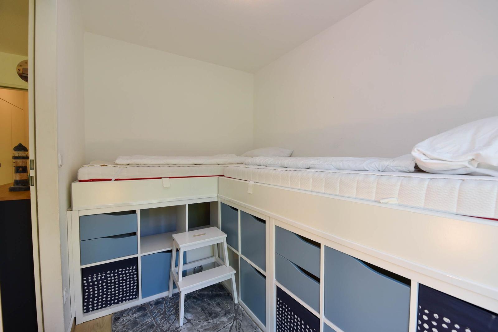 Zimmer mit zwei Matratzen aufgestellten Betten und integrierten Schubladen.