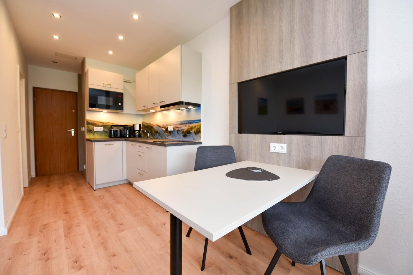 Küche mit Essbereich, Fernseher und Holzboden
