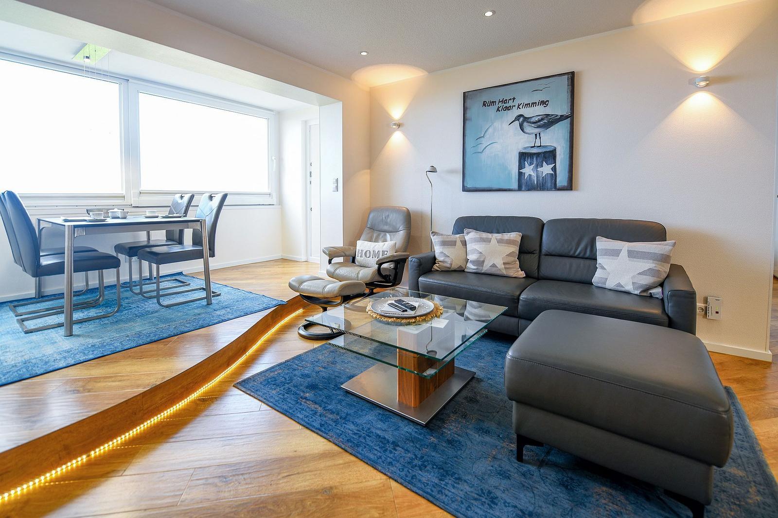 Living and dining area with sofa, dining table, and wall art.