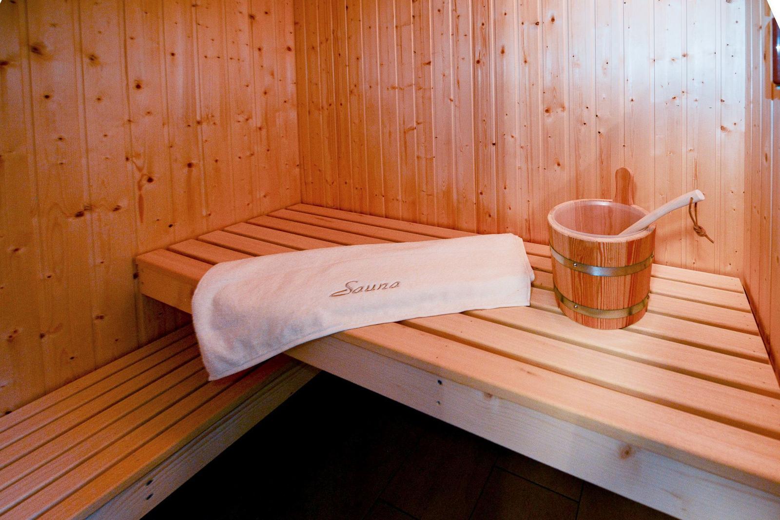 Sauna mit Holzbank, Handtuch und Eimer