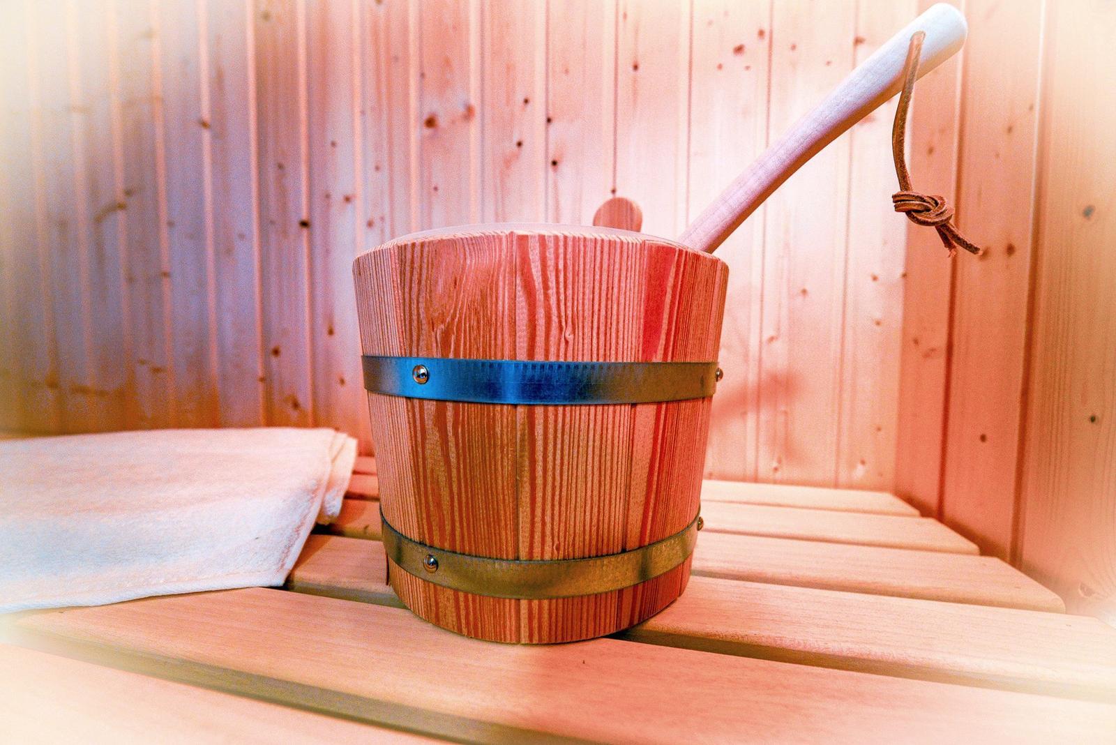 Holzwaschkarre mit Löffel auf Sauna-Bank