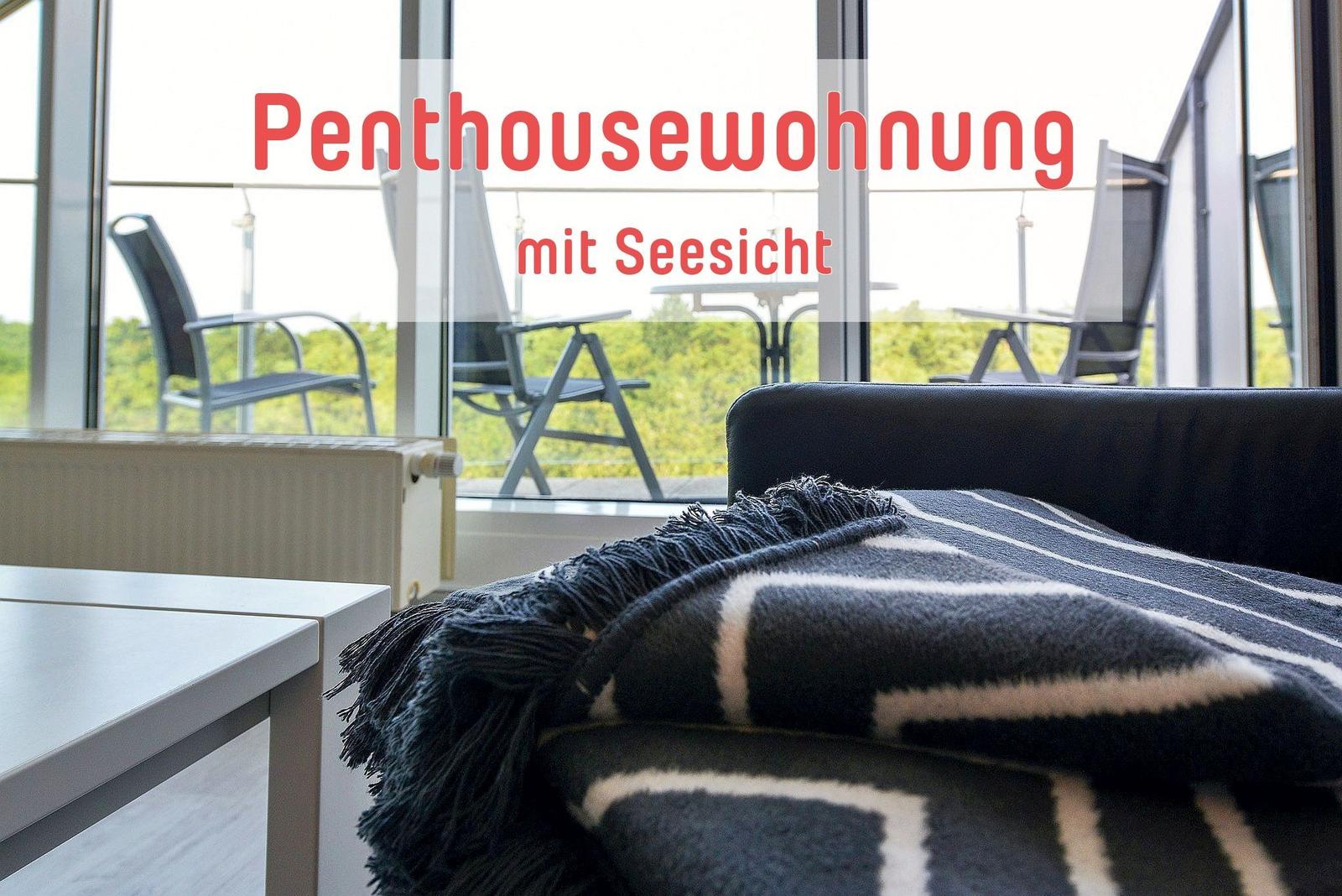Penthouse mit Seesicht, Blick auf Balkon mit Stühlen und Tisch.