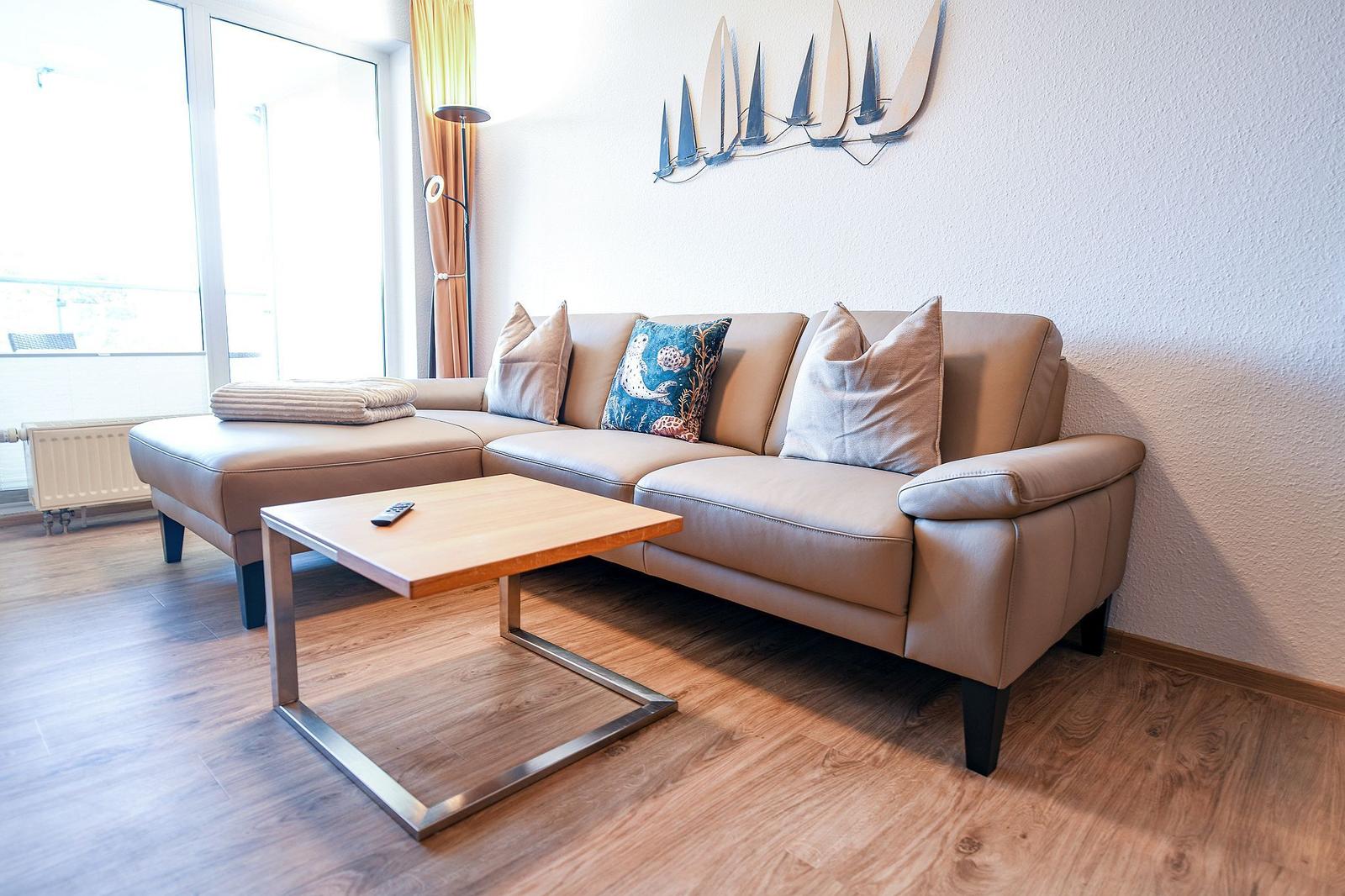Lichter Wohnzimmer mit Sofa, Couchtisch und Wanddekoration
