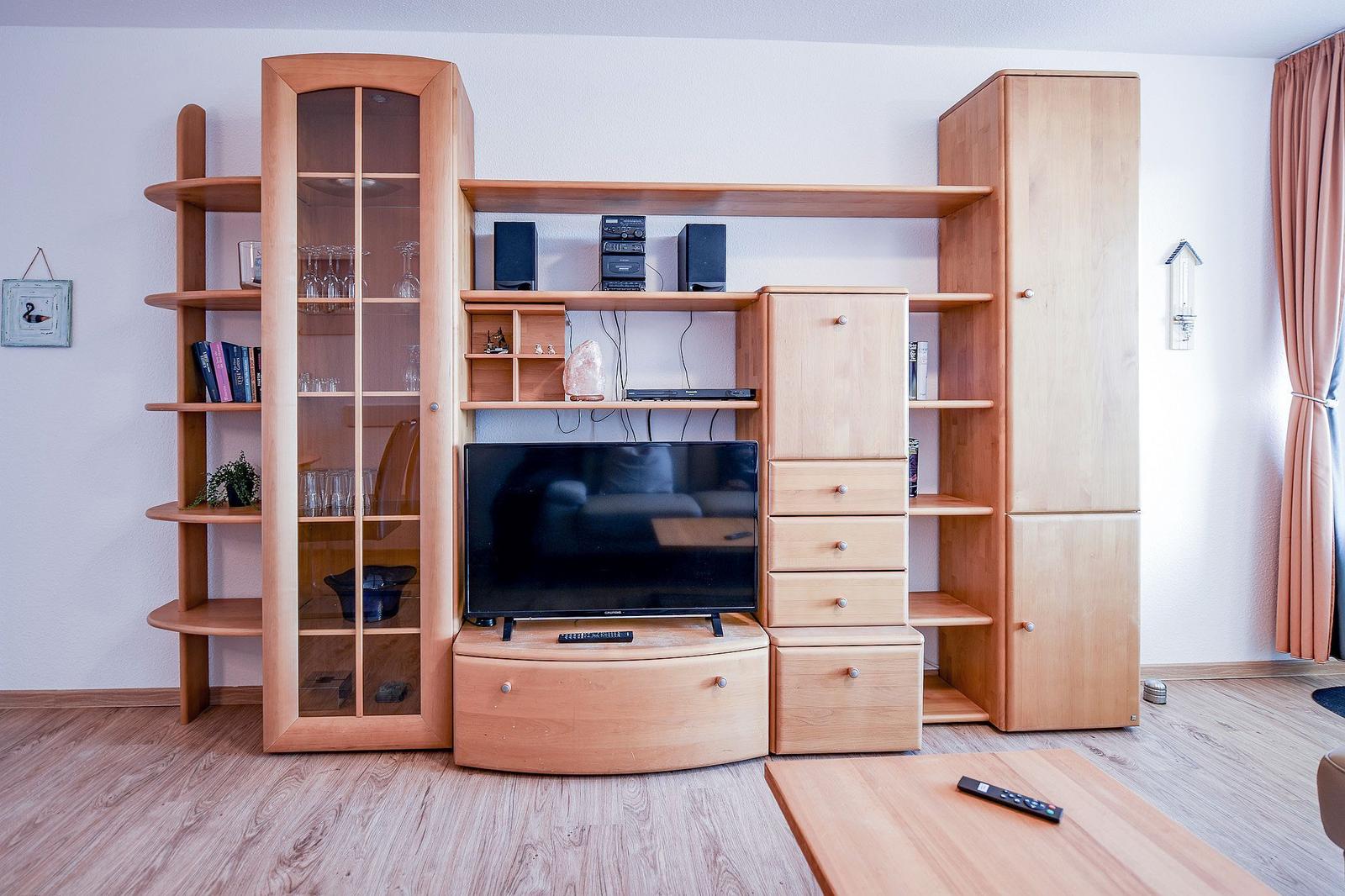 Holz-Möbel mit Fernseher, Regalen und Schubladen im Wohnzimmer.
