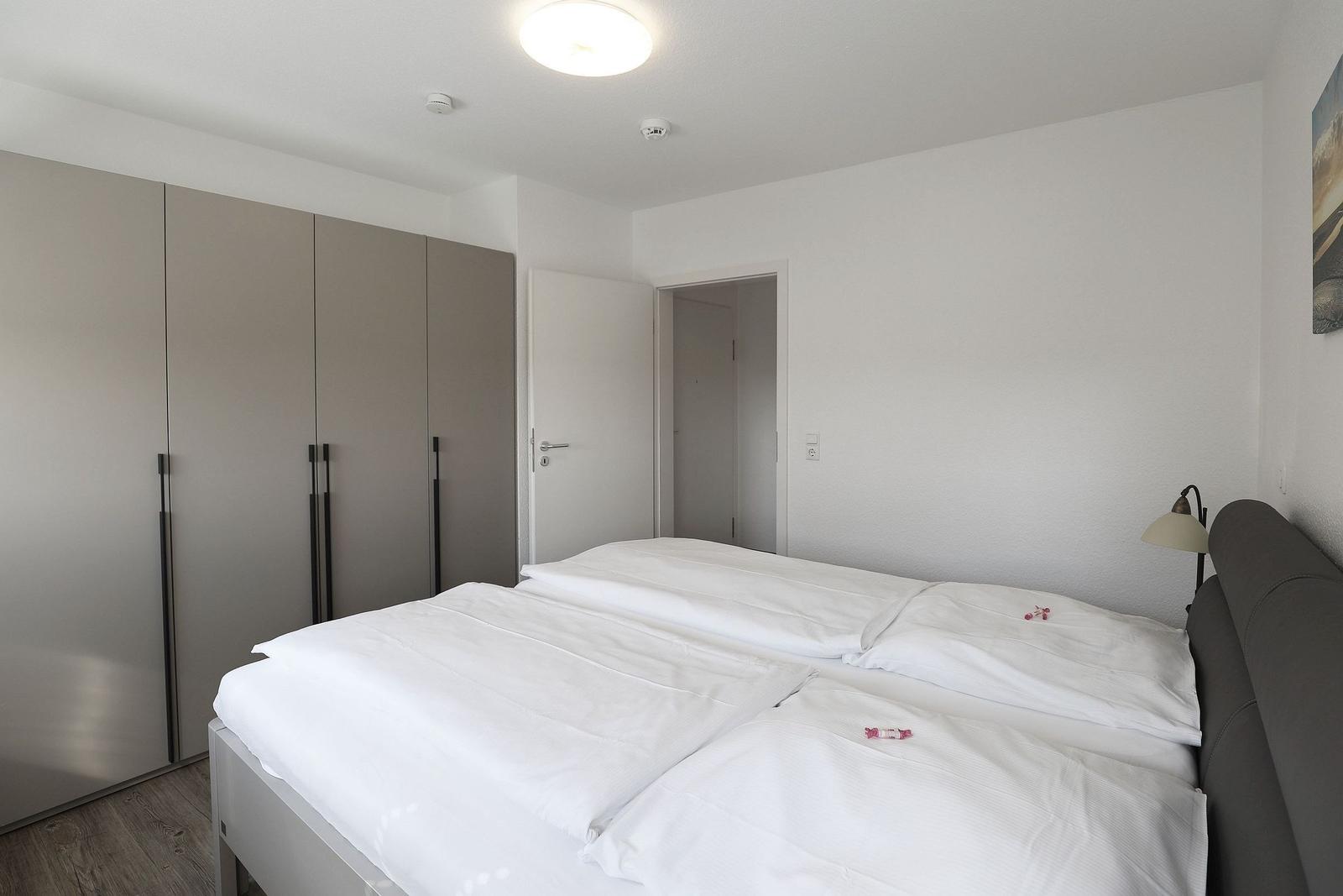 Bedroom with double bed, wardrobe, and bedside lamp.