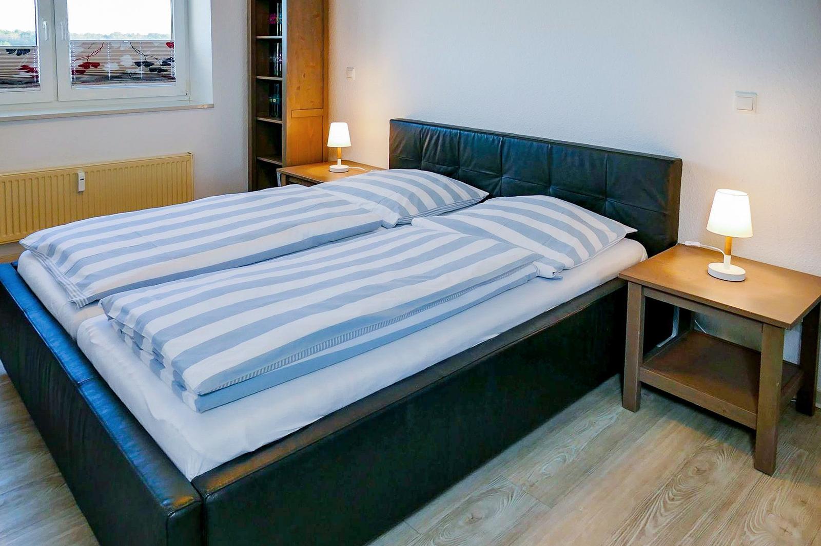 Schlafzimmer mit Doppelbett, zwei Nachttischen und Fenster mit Blick.