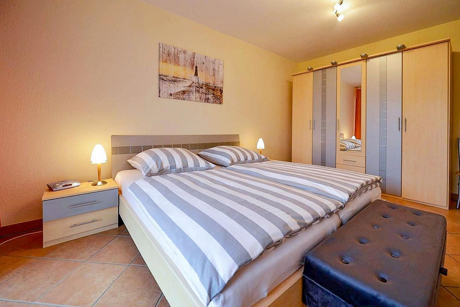 Schlafzimmer mit Doppelbett, Nachttisch und Kleiderschrank.