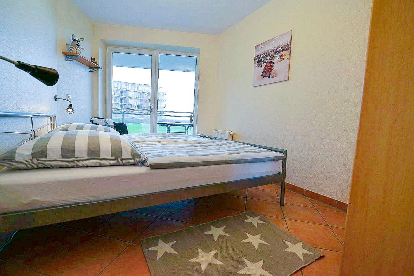 Schlafzimmer mit Bett, Fenster und Teppich
