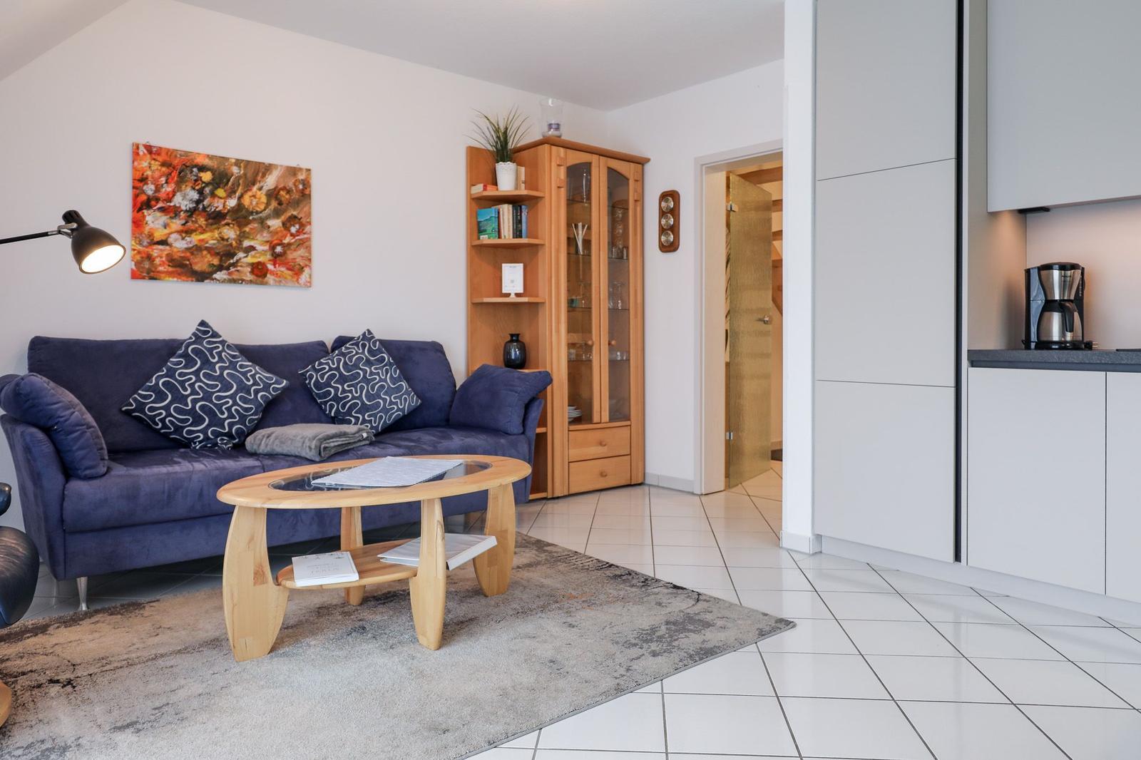 Ein Wohnzimmer mit Sofa, Couchtisch und Küchenbereich.